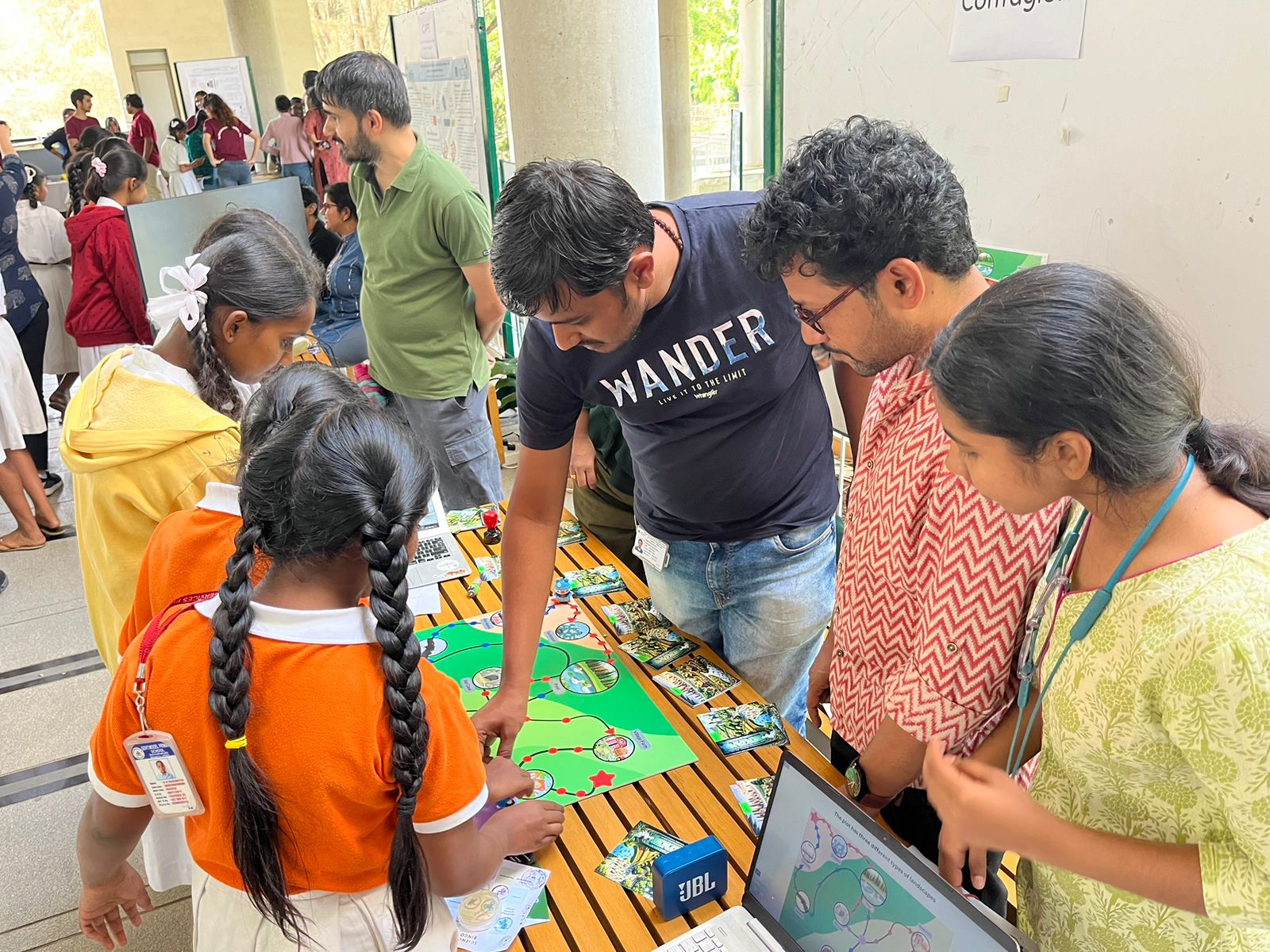 Three people explaining a board game for school students